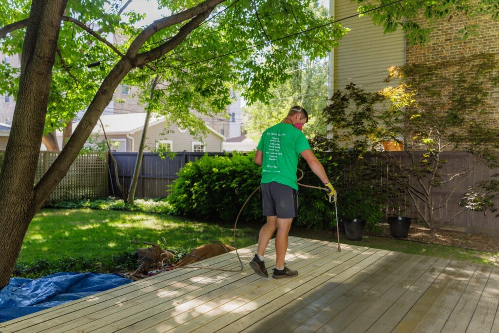 A man applying stain to a wooden deck.