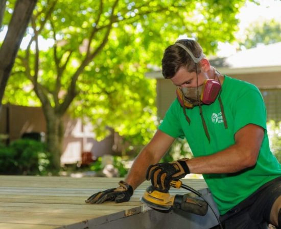 Wooden deck being smoothed with a sander