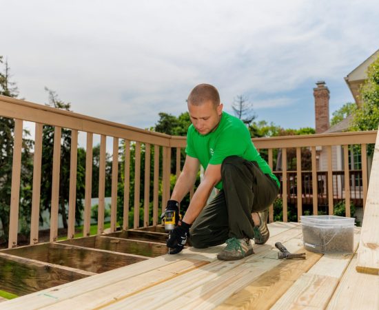 man repairing a wooden deck