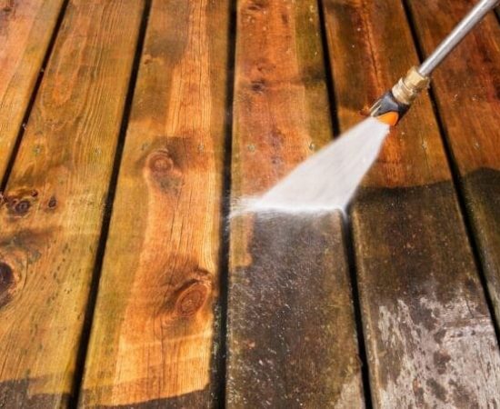 a person cleaning a wood deck