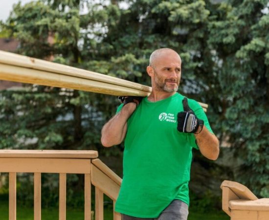 A man carrying timber for deck building.